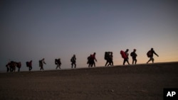 ARCHIVO - Migrantes centroamericanos caminan al final de la tarde cuando salen de Mexicali, México, el 20 de noviembre de 2018, en camino a Tijuana.