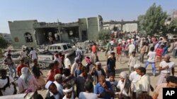 People gather at the al-Zaydiya security headquarters that was destroyed by Saudi-led airstrikes Saturday, in the Red Sea port city of Hodeida, Yemen, Sunday, Oct. 30, 2016.