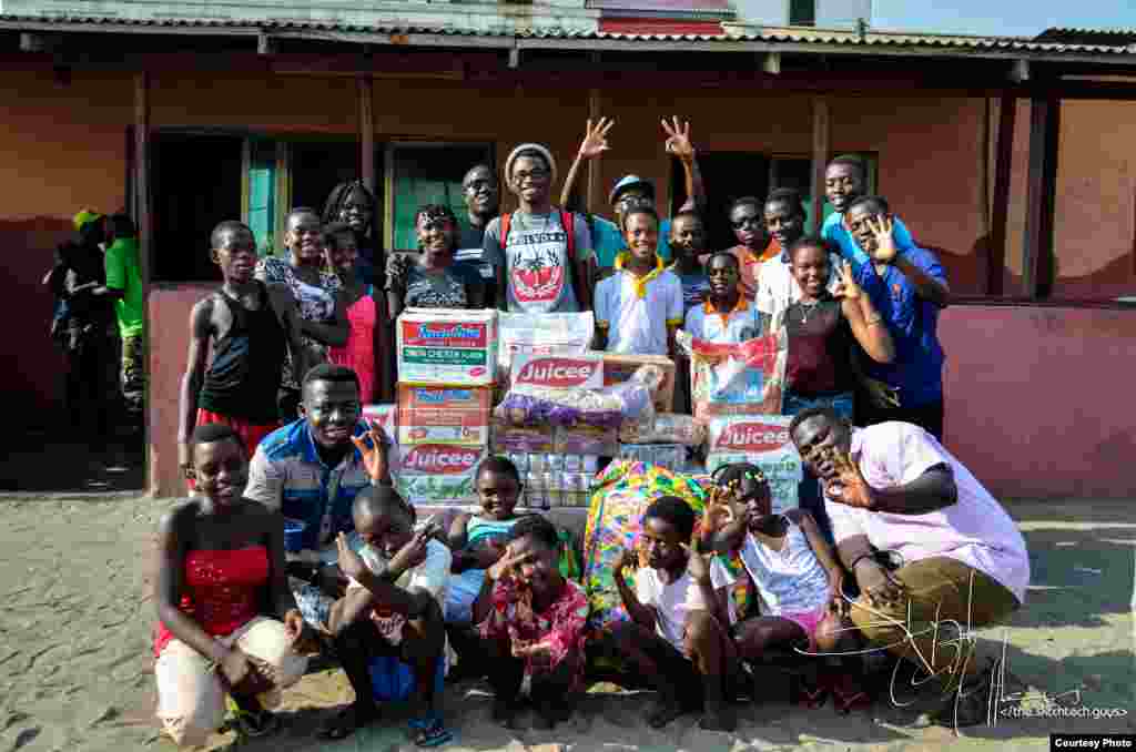 Boys and girls from suburban Accra's M'adamfo Pa Orphanage crowd around clothes and cases of soft drinks presented by several members of Team Tiki. (Courtesy Team Tiki)
