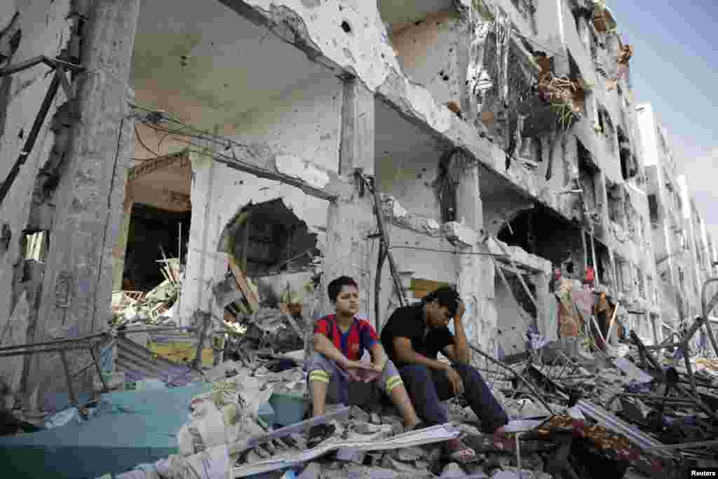Palestinians sit on the remains of their destroyed homes after returning to Beit Hanoun, which witnesses said was heavily hit by Israeli shelling and air strikes during the Israeli offensive, in the northern Gaza Strip, Aug. 5, 2014. 