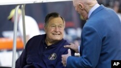 FILE - Former President George H.W. Bush talks with Houston Texans owner Bob McNair before a National Football League in Houston, Nov. 2014.
