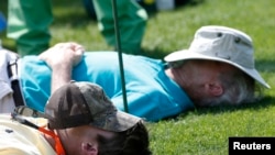 File - People nap on the 15th tee during Masters golf tournament in Augusta, Georgia, April 11, 2014. 