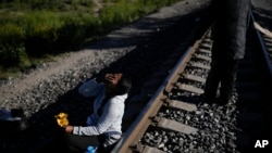 Una mujer migrante sentada al lado de las vías del tren con la esperanza de subirse a un tren de mercancías con ruta al norte en Huehuetoca, México, el miércoles 20 de septiembre de 2023. [AP/Eduardo Verdugo]