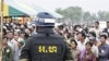 A Cambodian military policeman stands watch during the ground breaking ceremony of a Chinese funded road at Koun Damrey village, Banteay Meanchey province, about 15 kilometers (9 miles) east of Cambodia's border with Thailand, February 15, 2011.

