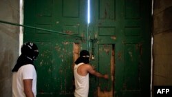 Warga Palestina mengamankan pintu masjid Al-Aqsa di Yerusalem, 27 September 2015, sementara mereka berjaga-jaga di dalam untuk melindungi masjid itu bila ada bentrokan lagi.