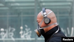 A man wearing a mask is seen on a street in Beijing May 2, 2013. Street-level anger over air pollution that blanketed many northern cities this winter spilled over into online appeals for Beijing to clean water supplies, especially after rotting corpses