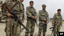 Afghan forces stand guard during a security transition ceremony from private security companies to the Afghan government in Kabul, March 15, 2012.