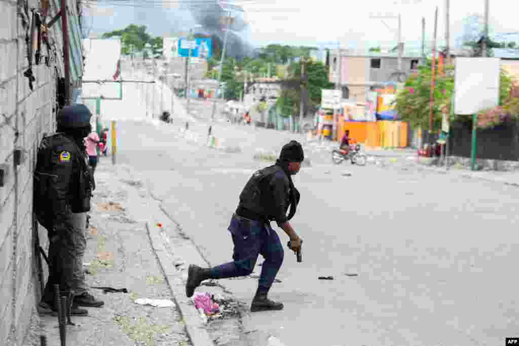 Un policía cruza una calle principal durante un tiroteo con pandillas. 