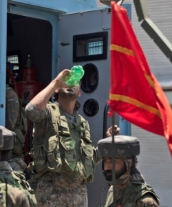An Indian soldier drinks water as they return from the site of a gun-battle in Srinagar, Indian controlled Kashmir, Sunday, June 21, 2020.