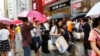 中国游客手提货物，在日本东京银座街道上等待旅游车。（2015年6月17号）
