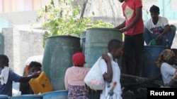ARCHIVO: La gente se reúne para comprar gasolina mientras la violencia se propaga y las bandas armadas amplían su control sobre la capital, en Puerto Príncipe, Haití, el 29 de marzo de 2024. 