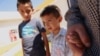 Salvadoran migrant Epigmenio Centeno and his sons, nine-year old Axel Jaret (L) and three-year old Steven Atonay, pose for a photograph outside the shelter House of the Migrant, after Epigmenio decided to stay with his children in Mexico due to U.S. Presi