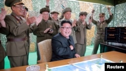 北韓領導人金正恩在一次導彈發射後與指揮人員在一起（資料照片）