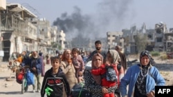 TOPSHOT - Palestinians displaced from shelters in Beit Hanoun cross the main Salaheddine road into Jabalia in the northern Gaza Strip following Israeli army evacuation orders on November 12, 2024, amid the ongoing war in the Palestinian territory between