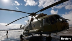FILE - An Afghan soldier walks next to an Mi-17 helicopter at the military airport in Kabul, Jan. 17, 2008. 