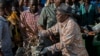 FILE - Tanzanian President John Magufuli joins a cleanup event outside the State House in Dar es Salaam on Dec. 9, 2015. Magufuli canceled Independence Day celebrations and ordered a national day of cleanup instead.