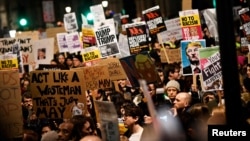 Demonstrators hold placards during a protest against U.S. President Donald Trump's executive order travel ban in London, Britain, Jan. 30, 2017. 