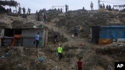 ARCHIVO - Los palestinos recurren al agua del mar para bañarse y limpiar sus herramientas y ropa debido a la continua escasez de agua en la Franja de Gaza, el 29 de octubre de 2023.