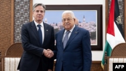 Presiden Otoritas Palestina Mahmud Abbas dan Menteri Luar Negeri AS Antony Blinken berjabat tangan sebelum pertemuan di Muqata, kompleks kepresidenan di Kota Ramallah Tepi Barat, pada 30 November 2023. (Foto: AFP)