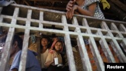 Muslim people pass the time at their house in Paik Thay, the site of recent violence between Muslim Rohingyas and Buddhist Rakhine people in Burma, November 2, 2012.