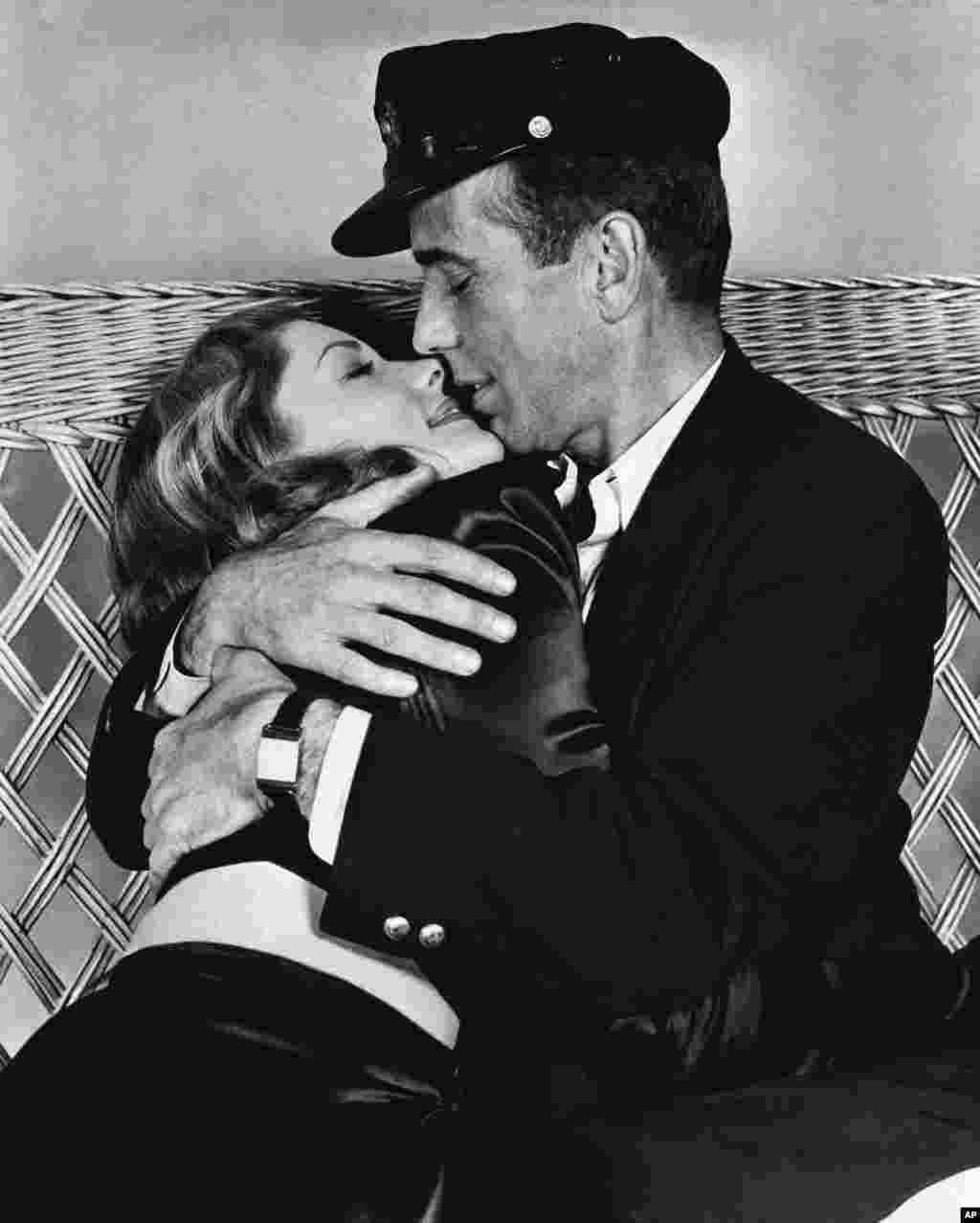Actor Humphrey Bogart holds actress Lauren Bacall in a tight embrace in their film "To Have and Have Not", in their first appearance on the screen, January 14, 1957.