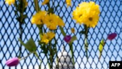 Flores adornan la cerca que rodea el Capitolio de Estados Unidos en Washington, DC, el 3 de abril de 2021, en honor al oficial de policía del Capitolio, William Evans, en Washington, DC.