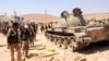 Free Syrian Army fighters inspect munitions and a tank that belonged to forces loyal to Syria's President Bashar al-Assad after they seized Khanasir, August 26, 2013. 