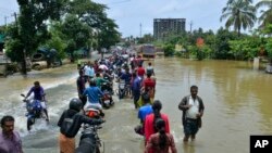 Masyarakat bergerak melewati kawasan yang terdampak banjir di Thrissur, wilayah selayan negara bagian Kerala, India, 17 Agustus 2018. (foto: dok). 