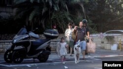 Los israelíes reaccionan en una calle mientras se lanzan ataques con cohetes desde la Franja de Gaza, en Tel Aviv, Israel, el 7 de octubre de 2023. [REUTERS]