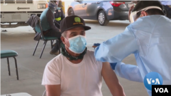 Cientos de inmigrantes hicieron fila para convertirse en algunos de los primeros trabajadores agrícolas de EE.UU. en recibir vacunas contra el COVID-19 en el condado Riverside, California. [Foto: tomada de vídeo original de la VOA]