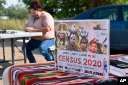 Selena Rides Horse enters census information into her phone on behalf of a member of the Crow Indian Tribe in Lodge Grass, Montana, Aug. 26, 2020.