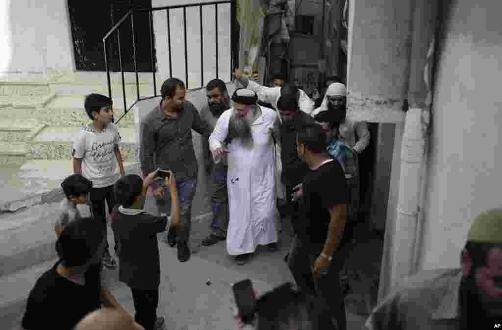 Abu Qatada is welcomed by family and friends as he arrives at his family home in Amman, Sept. 24, 2014.