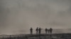 Un grupo de migrantes es detenido por miembros de la Guardia Nacional de Estados Unidos en Eagle Pass, Texas, visto desde Piedras Negras, México.