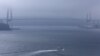 A boat cruises the sea in front of a bridge linking Russian Island (L) to the mainland, in Russia's far Eastern port of Vladivostok, September 5, 2012.