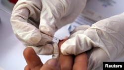 FILE - A nurse takes blood for a free HIV test during an HIV prevention campaign marking World AIDS Day in Lima, Peru, Dec. 1, 2016. 