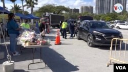 Cientos de personas acuden a la sede del ayuntamiento de la ciudad de Miami para recibir una cesta con comida para el día de Acción de Gracias. Foto: Antoni Belchi, VOA.