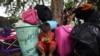 Un niño emplea un teléfono celular entre sus pertenencias después de que él y su familia cruzaron en bote el río Arauca, la frontera natural entre Venezuela y Colombia, hacia Arauquita, Colombia, el viernes 26 de marzo de 2021.