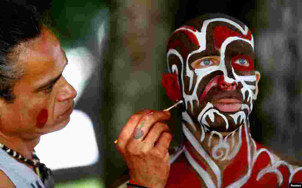 An artist touches up makeup on a model during the "World Bodypainting Festival 2017" in Klagenfurt, Austria.