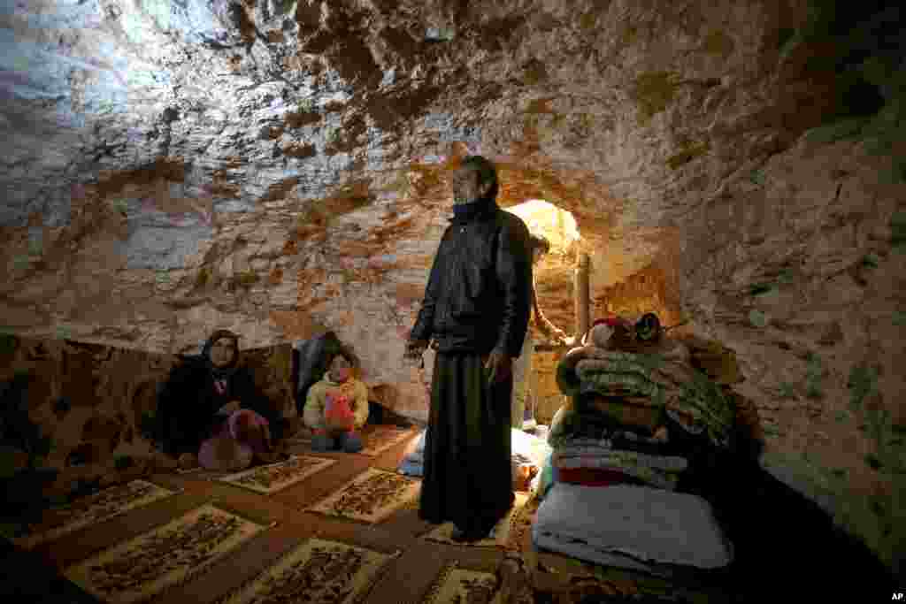 Sobhi al-Hamod, 60, stands inside an underground shelter he made using a jackhammer to protect his family from Syrian government forces shelling and airstrikes, Jirjanaz, Idlib province, Syria, Feb. 28, 2013.
