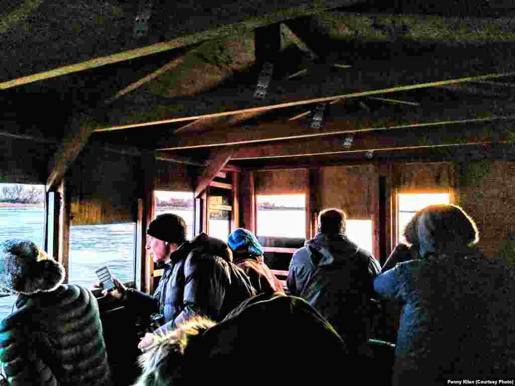 As the sun rises, crane watchers look out the holes in the blinds at Aububon's Rowe Sanctuary to spot sandhill cranes perched on the river or flying overhead, near Gibbon, Nebraska, March 16, 2019.
