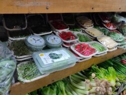 Boxes of hydroponic greens are displayed among other vegetables. (Anjana Pasricha/VOA)