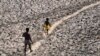 ARCHIVES - Un homme et un garçon traversent le lit asséché de la rivière Yamuna à New Delhi, en Inde, le lundi 2 mai 2022.