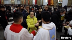 El debate sobre si los sacerdotes católicos deben poder casarse existe desde hace siglos. Los que se oponen afirman que el celibato permite a un sacerdote dedicarse por entero a la Iglesia. En la foto, un sacerdote da la comunión en una misa en China, el 24 de diciembre de 2023.