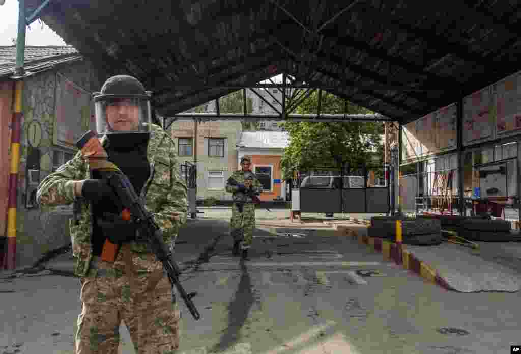Pro-Russian armed men walk in an entrance to a border guard base, which they seized, on the outskirts of Luhansk, Ukraine, June 4, 2014.