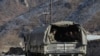 FILE - Azerbaijani soldiers sit in a military truck taking them to their military tent camp, in Kalbajar, Azerbaijan, Dec. 2, 2020. 