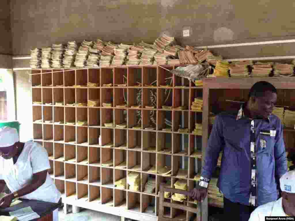 Patient information and immunization records are kept on paper at an open air clinic, Benin, Africa. (Sunpreet Arora)