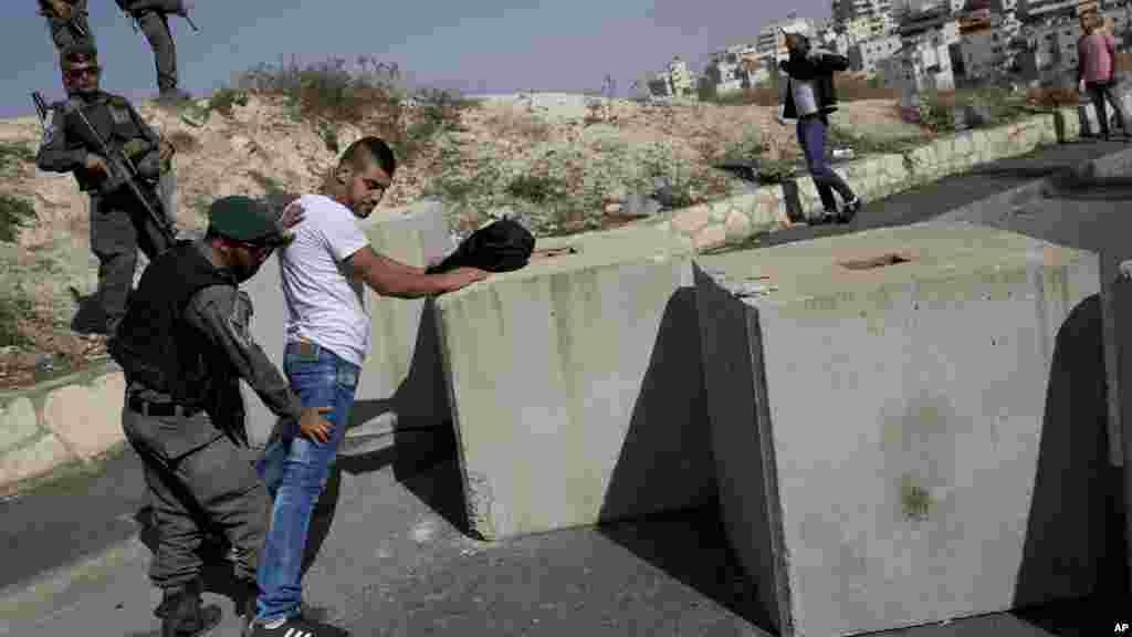 'Yan Sanda masu gadin Iyakar Isira'ila na caje wani bafalastine, kusa da wani sabon guri da aka gina dake gabashin unguwar Jerusalem. 