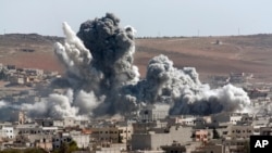 Asap mengepul akibat serangan udara AS terhadap posisi ISIS di Kobani, Suriah (22/10).