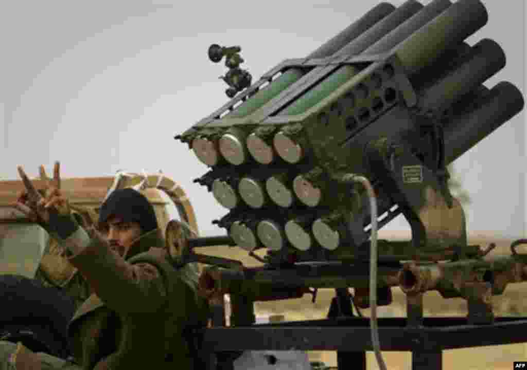 A Libyan rebel flashes the victory sign as he arrives with his weapon to the frontline near Sultan, south of Benghazi, Libya, Friday, March 18, 2011. The U.N. Security Council voted Thursday to impose a no-fly zone over Libya and authorize "all necessary