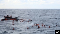 File - Refugees and migrants are rescued by members of the Spanish NGO Proactiva Open Arms, after leaving Libya trying to reach European soil aboard an overcrowded rubber boat in the Mediterranean sea, Nov. 11, 2020.